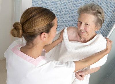 therapist assisting elderly woman for shower