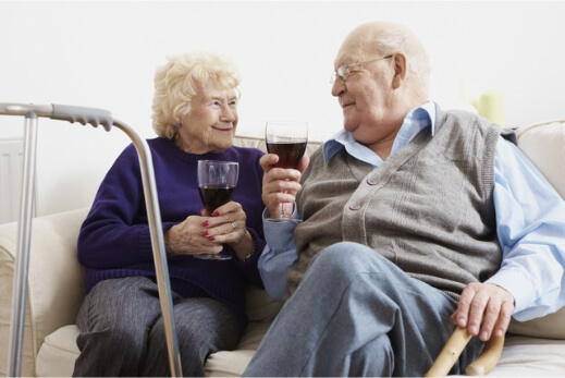 elderly couple enjoying a glass of wine